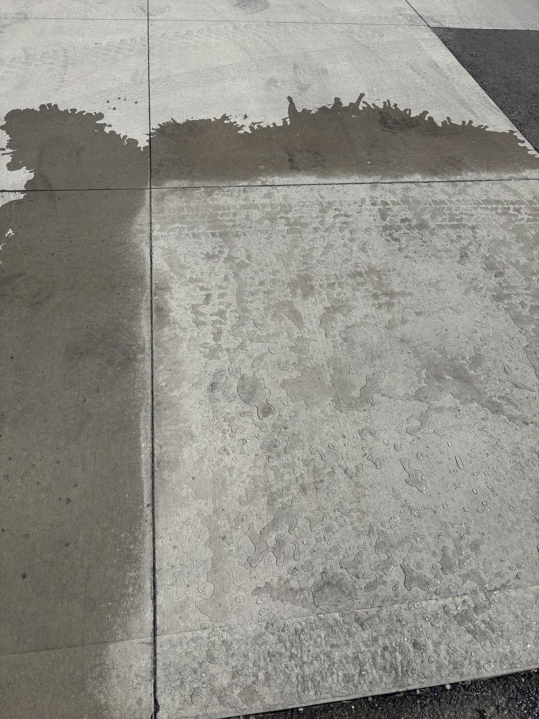 Concrete Saver treated section of a driveway with water beading and running off the surface