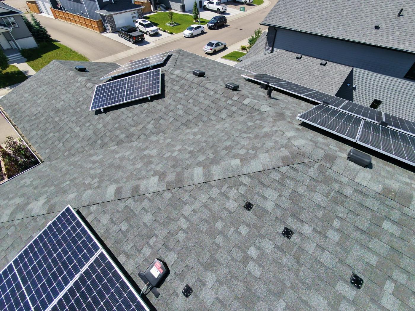Aerial view of a shingle roof with solar panels treated with NuRoof