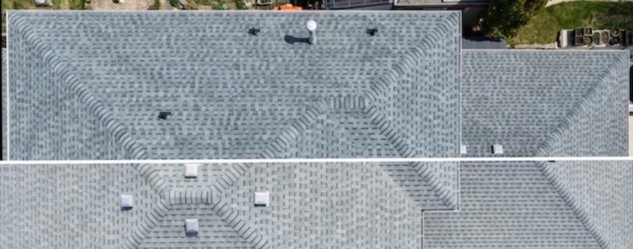 Split aerial before-and-after comparison of a treated shingle roof.