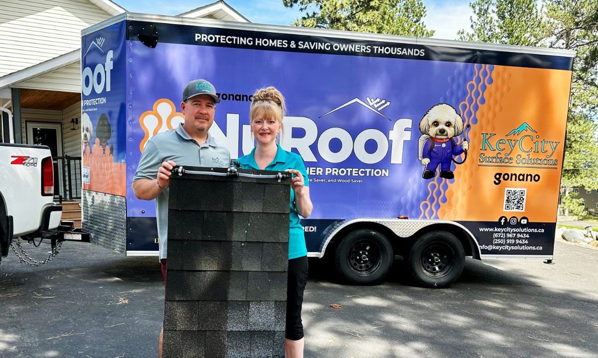 Jeff and Crystal holding up a piece of roofing to show the improvement on the side where NuRoof was used.